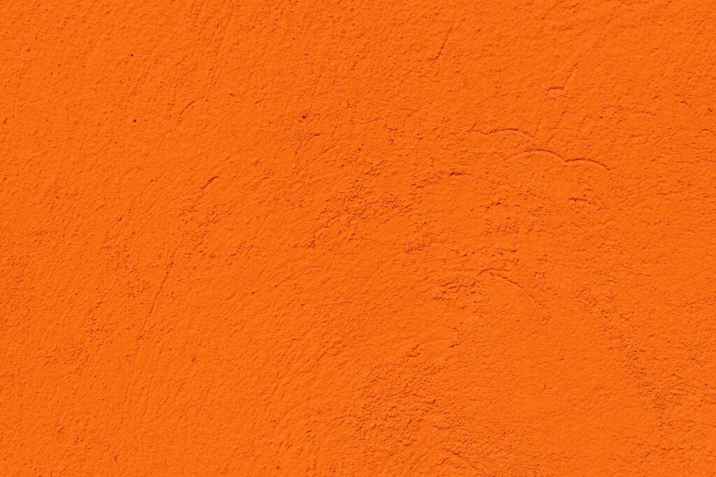 Orange color textured concrete wall with space for text